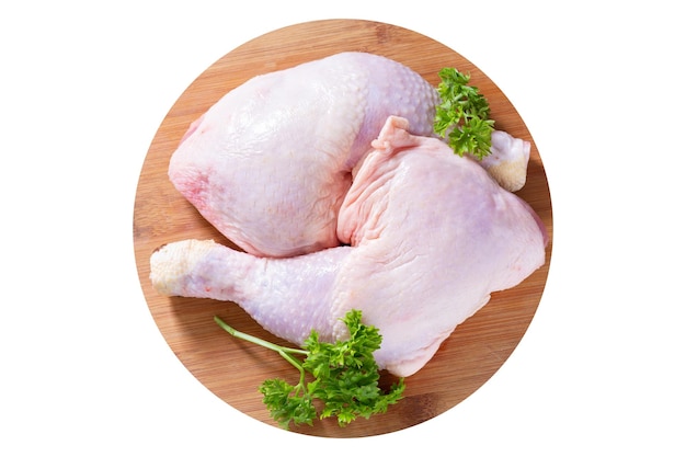 Cuisses de poulet frais avec du persil sur une planche de bois isolé sur fond blanc