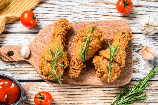 Cuisses de poulet frites croustillantes sur une planche de bois