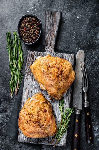 Cuisses de poulet grillées au barbecue épicé sur une planche de bois au romarin