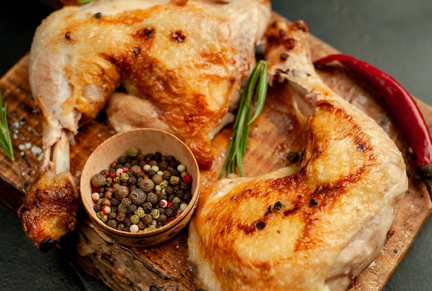 cuisses de poulet grillées aux épices et herbes, prêtes à cuire sur un fond de pierre.