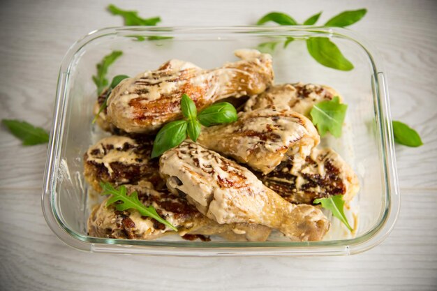 Cuisses de poulet grillées frites avec des épices et des herbes dans une sauce à l'ail