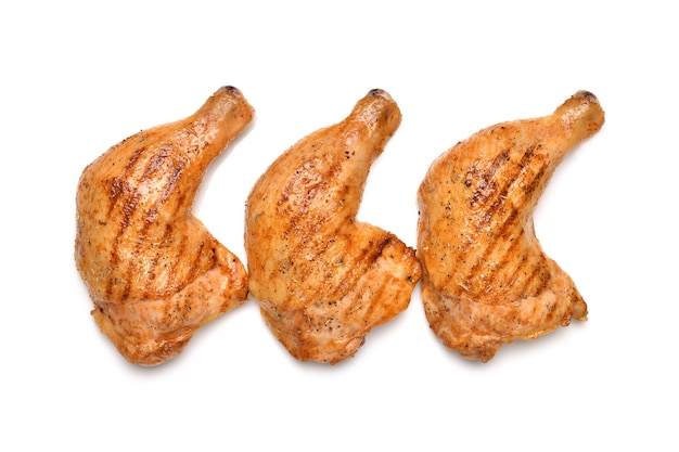 Cuisses de poulet grillées isolées sur une surface blanche