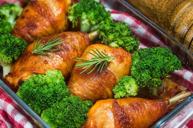 Cuisses de poulet avec des légumes sur une table en bois.