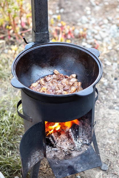 Cuisson des aliments ou du pilaf dans un chaudron en feu Cuisson dans un chaudron à feu ouvert dans la nature