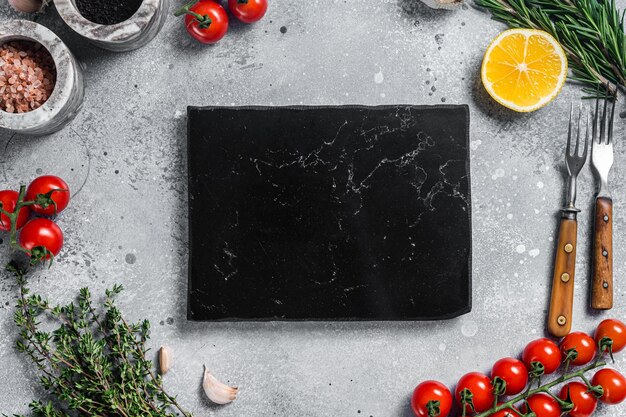 Cuisson des aliments et fond de saine alimentation avec planche à découper en bois et herbes et légumes d'assaisonnement frais Fond gris Vue de dessus Espace de copie