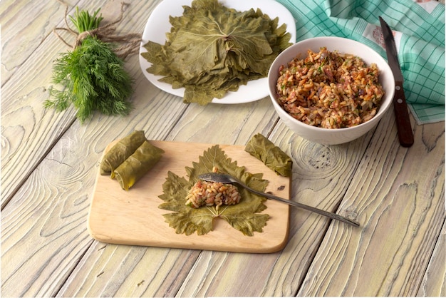 Cuisson des aliments Préparation de dolmas en feuilles de vigne sur une table en bois libre