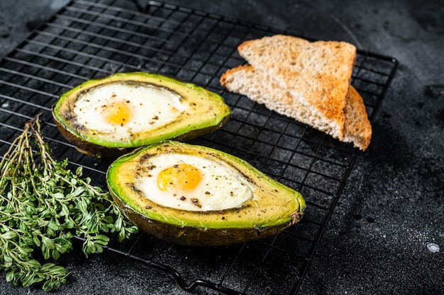 Cuisson de l'avocat au four avec oeuf Fond noir Vue de dessus