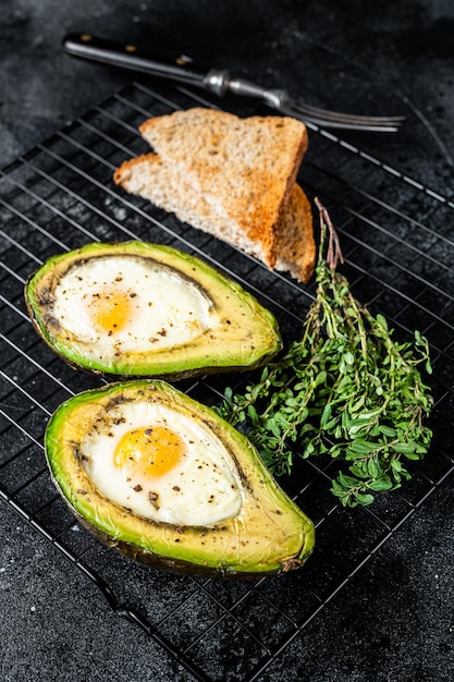 Cuisson de l'avocat au four avec oeuf Fond noir Vue de dessus