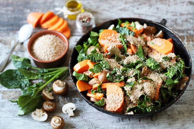 Cuisson de la bouillie de blé végétalienne avec des légumes et des champignons.