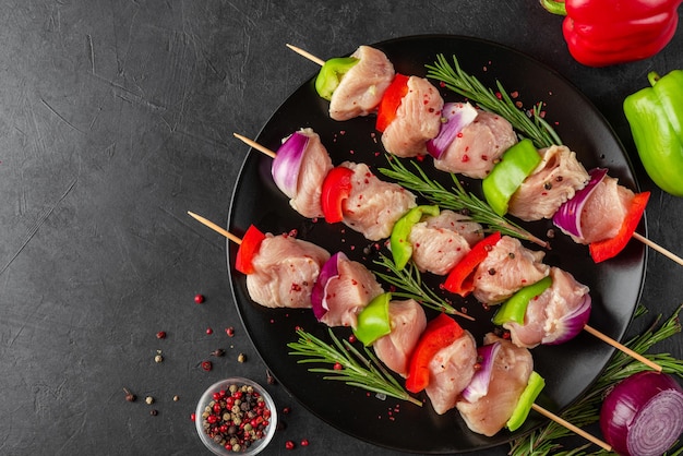 Cuisson de la brochette de poulet avec des légumes Viande de poulet crue sur des brochettes pour le grill ou le barbecue Vue de dessus Préparation du barbecue