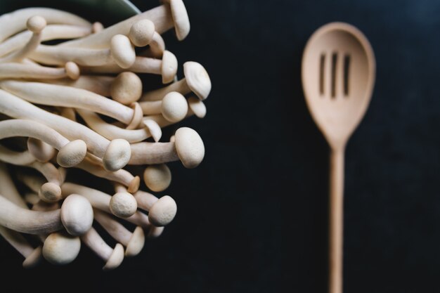 Cuisson des champignons blancs et cuillère en bois