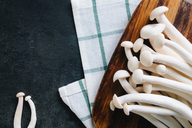 Cuisson des champignons blancs sur fond gris foncé. Photo de haute qualité