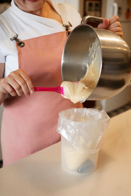 Photo cuisson confiseur femelle avec de la pâte dans une pâtisserie