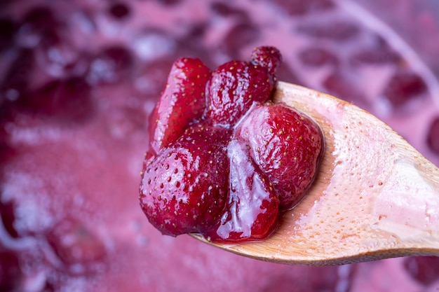 Cuisson de la confiture de fraises dans un pot en argent sur la cuisinière