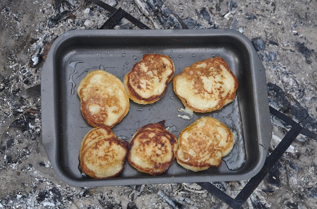 Cuisson des crêpes sur un feu en conditions de terrain