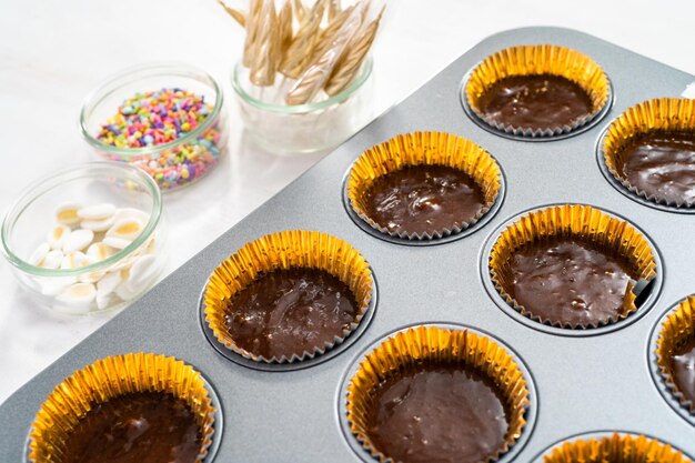 Cuisson des cupcakes au chocolat dans un moule à cupcake.