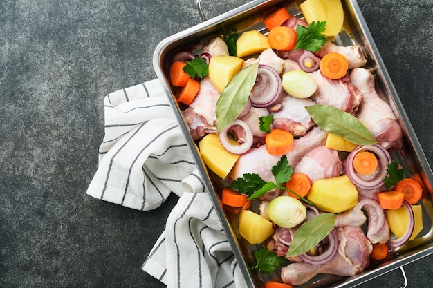 Cuisson du bouillon de poulet ou du rôti dans une casserole ou une marmite avec des légumes pommes de terre carottes et herbes sur le paysage de plan de travail en béton gris de la cuisine d'en haut Cuisson préparation du bouillon de poulet Maquette