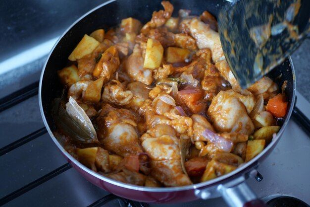 Cuisson du curry de poulet dans une casserole