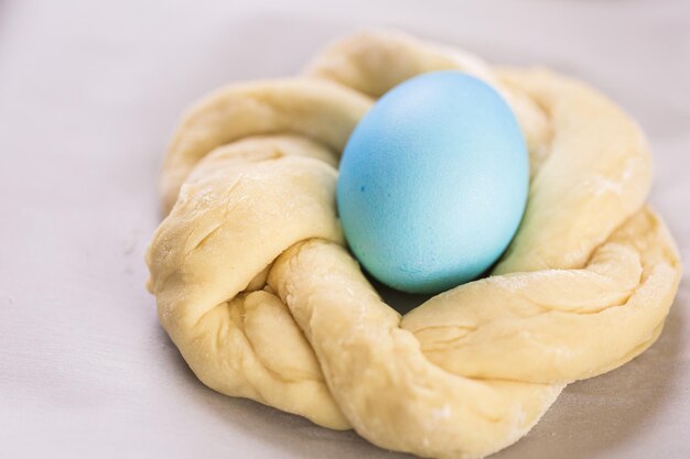 Cuisson du pain de Pâques italien avec un œuf de couleur bleue.