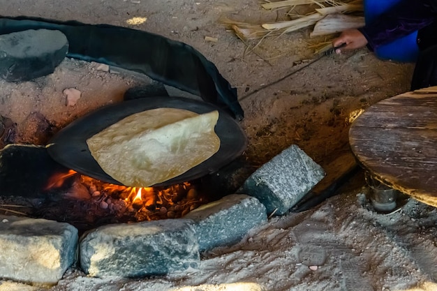 Cuisson du pain pita au feu dans une habitation bédouine