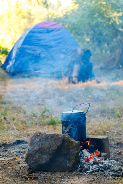 Cuisson sur feu de camp en camping Tente et sac à dos sur fond