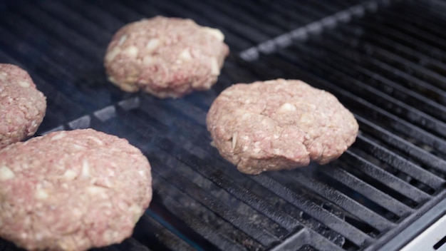 Cuisson des galettes de boeuf hamburger sur un gril à gaz.