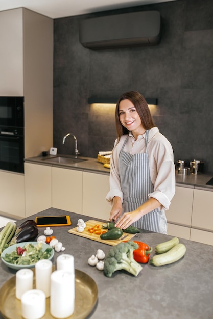 Cuisson. Jeune femme au foyer aux cheveux longs cuisinant dans la cuisine