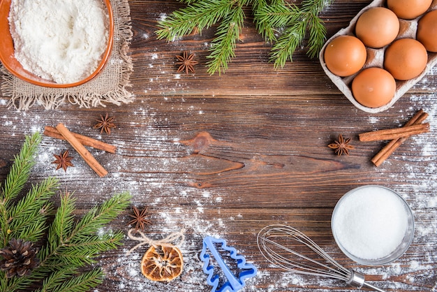 Cuisson de Noël de biscuits au gingembre sur bois foncé avec des branches de sapin.