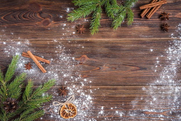 Cuisson de Noël de biscuits au gingembre sur fond de bois foncé avec des branches de sapin.