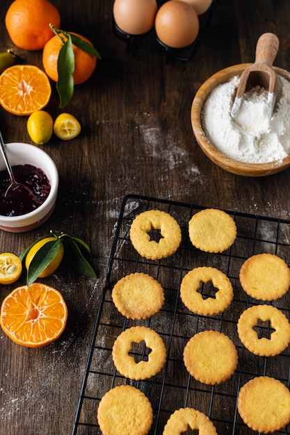 Photo cuisson de noël, biscuits linzer traditionnels avec confiture d'orange et de baies sur table en bois