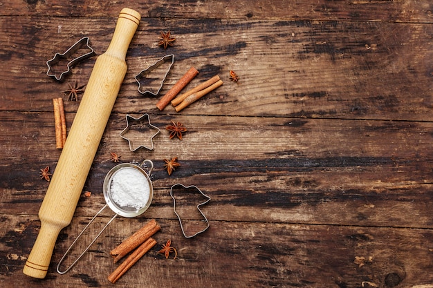 Cuisson de Noël - étoiles, ange et sapin, tamis, sucre en poudre et rouleau à pâtisserie.