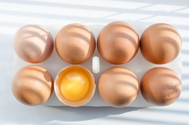 Cuisson des œufs à partir d'œufs de poule tôt le matin dans la cuisine Ombres des volets sur le rebord de la fenêtre