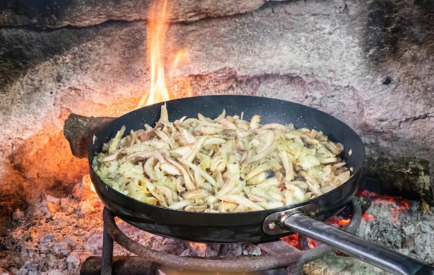 Cuisson d'un oignon frit et de piment de Cayenne avec de l'huile d'olive dans une poêle en fonte