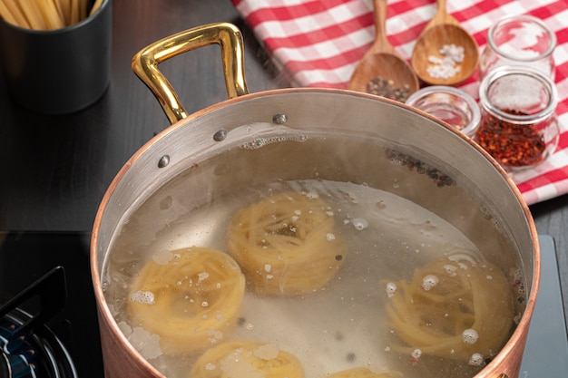 Photo cuisson des pâtes à la cuisine à domicile dans une casserole bouchent