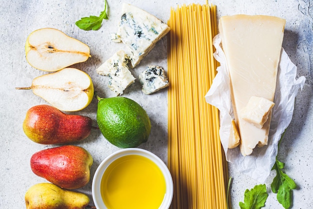 Cuisson des pâtes fond Ingrédients crus pour les pâtes à la poire et au fromage sur fond gris