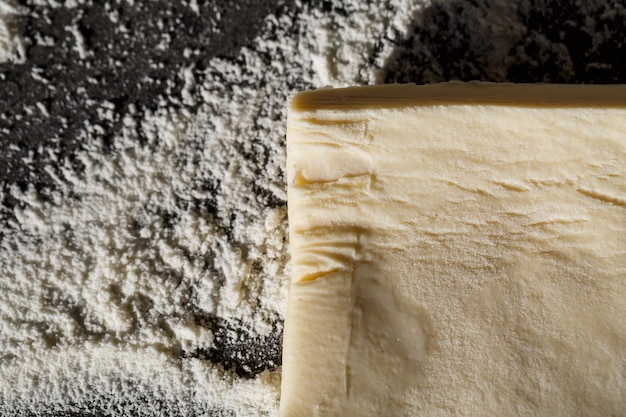 Cuisson à plat poser sur la table la pâte, la farine sur fond gris. Menu de cuisson, recette, concept de pâtisserie maison. Vue de dessus avec espace de copie pour votre texte.