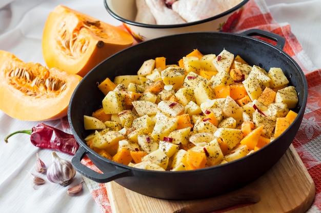 Cuisson d'un repas en pot - cuisses et cuisses de poulet avec pommes de terre et citrouille