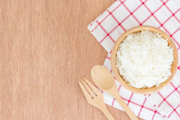 Cuisson de riz thaïlandais au jasmin ou de riz blanc dans un bol en bois sur fond en bois