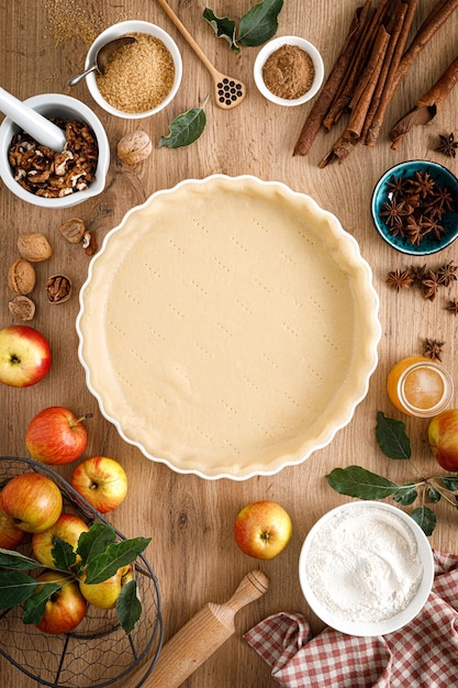 Cuisson de la tarte aux pommes d'automne de Thanksgiving avec des fruits frais et des noix sur la vue de dessus de table en bois