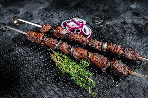 Cuit sur le grill shish kebab de boeuf aux légumes et épices viande grillée Fond noir Vue de dessus