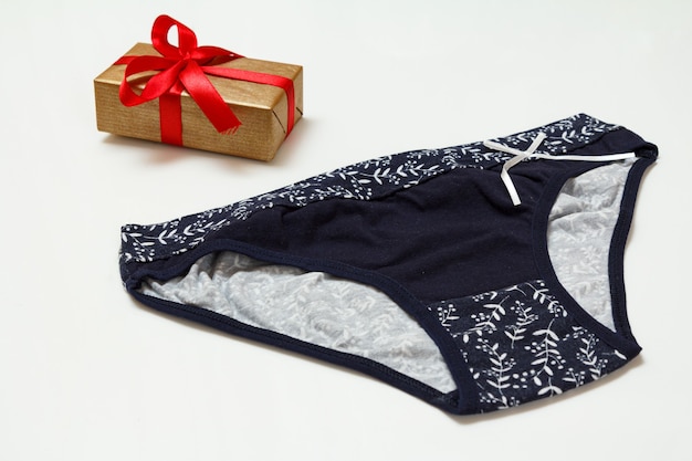 Culotte en coton noir et coffret cadeau sur fond blanc. Ensemble de sous-vêtements femme. Vue de dessus.