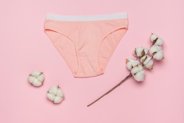 Culotte orange avec une bande blanche et un brin de coton sur fond orange Concept minimal de sous-vêtements féminins