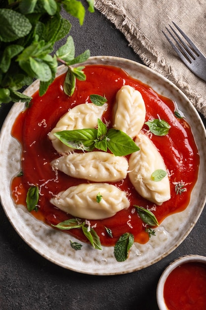 Culurgiones de cuisine italienne traditionnelle avec sauce tomate et basilic