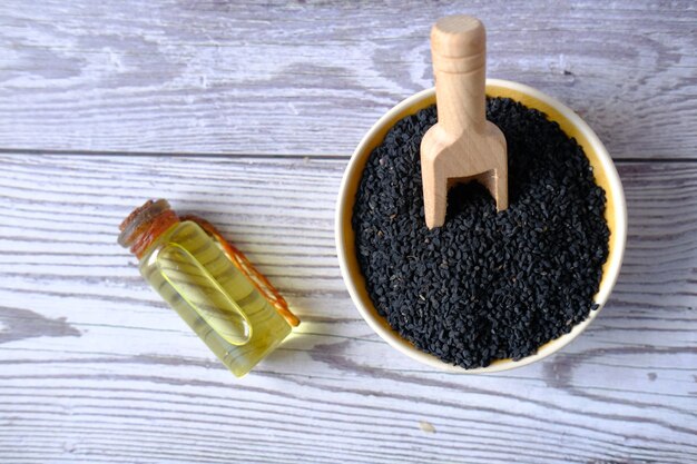 Cumin noir dans un récipient avec de l'huile dans un bocal sur table