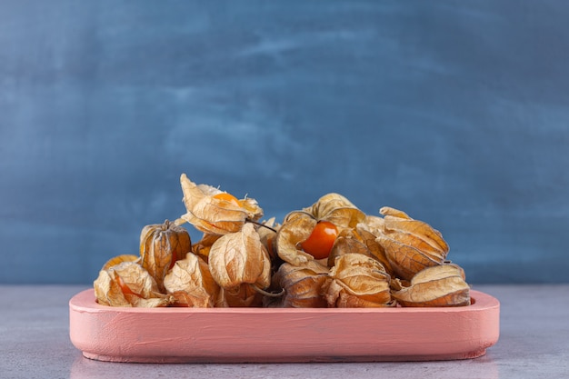 Cumquats séchés sains placés sur un tableau rose.