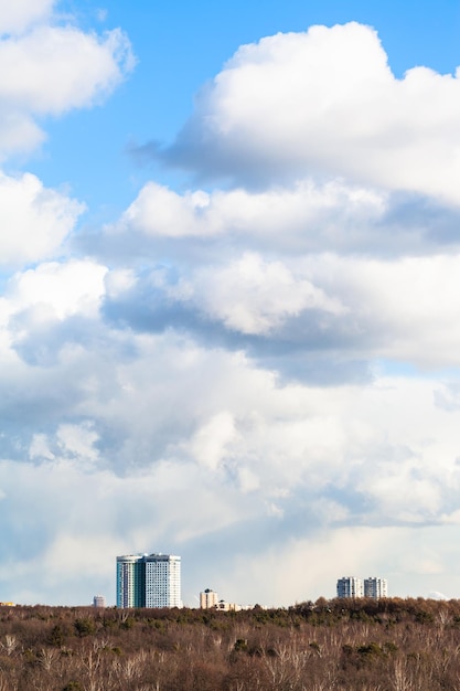 Cumulus dans le ciel au-dessus des bâtiments et des bois