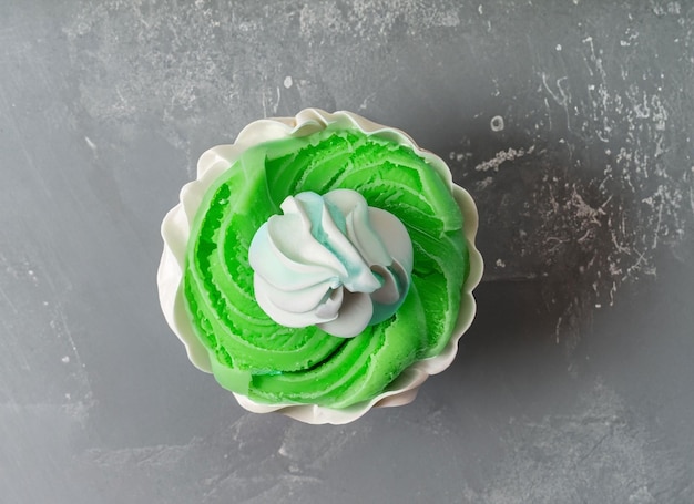 Cupcake d'anniversaire perlé avec glaçage à la crème au beurre sur la vue de dessus de fond gris