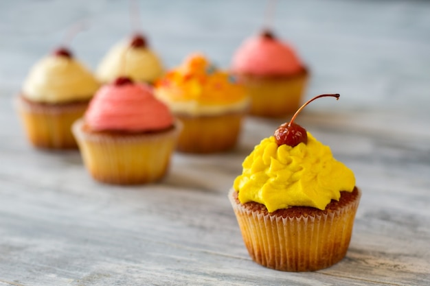 Cupcake aux baies sur le dessus glaçage jaune vif dessert savoureux avec crème au beurre délicieux dans votre ventre