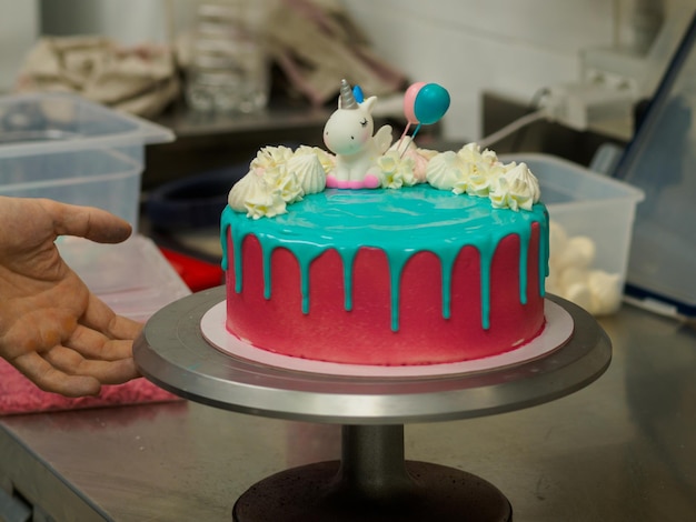 Cupcake bleu rose givré avec pépites de meringue sucrée et garniture de licorne