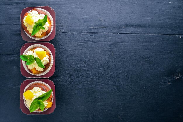 Cupcake à la crème et aux fruits frais Sur un fond en bois Vue de dessus Espace libre pour votre texte